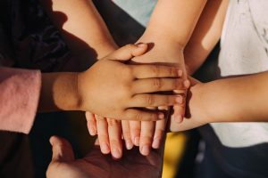 kids hands together with family and friends team
